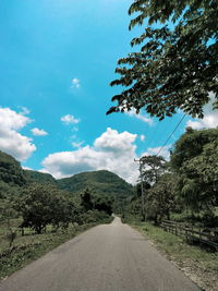 Road amidst trees against sky