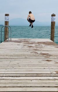 A teenager jumps into a lake 