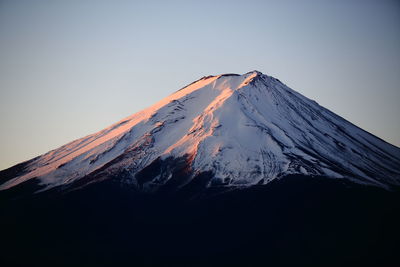 Low angle view of snowcapped mountain against clear sky