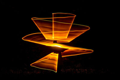 Close-up of illuminated lighting equipment against black background