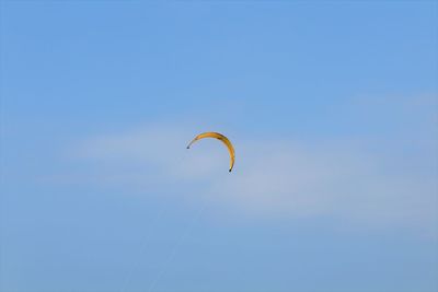 Low angle view of person paragliding against clear blue sky