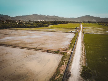 Road amidst field against sky