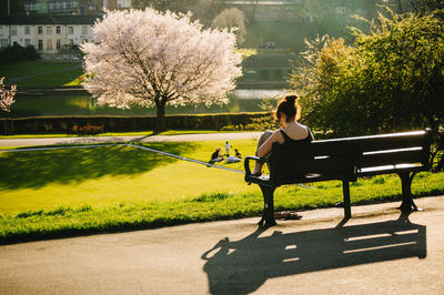 Woman sitting on bench in park