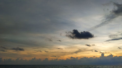 Scenic view of sea against dramatic sky during sunset