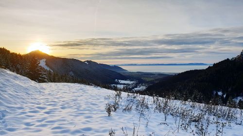 Scenic view of snowcapped mountains against sky during sunset