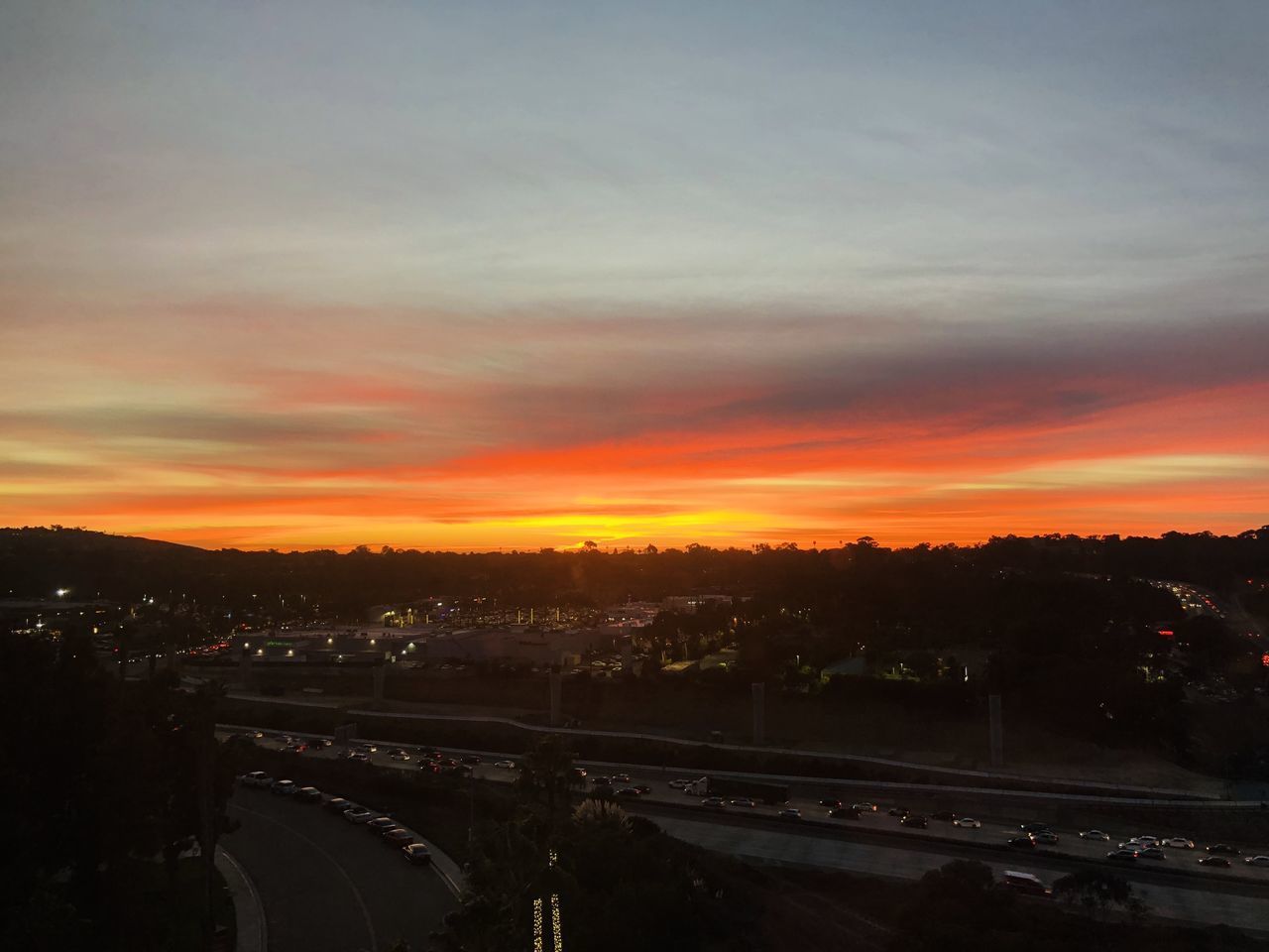 HIGH ANGLE VIEW OF HIGHWAY AGAINST SKY DURING SUNSET