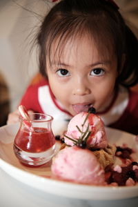 Close-up portrait of cute girl with strawberry ice cream in plate