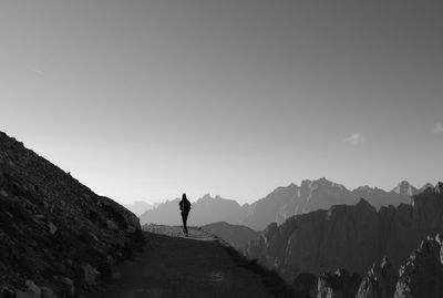 Rear view of man standing on mountain against sky