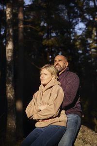 Couple resting in forest at sunny day