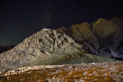 Rock formation on land against sky at night