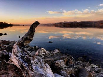 Scenic view of lake against sky at sunset