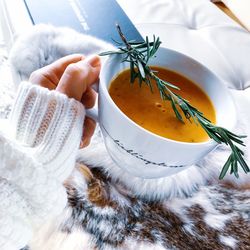 Cropped hand of woman holding soup in cup