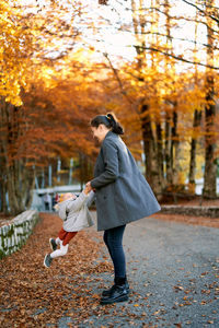 Rear view of woman walking on road