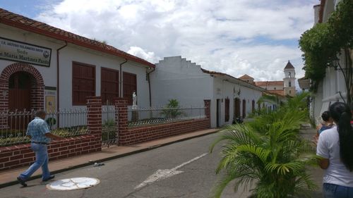 People walking on road amidst buildings in city