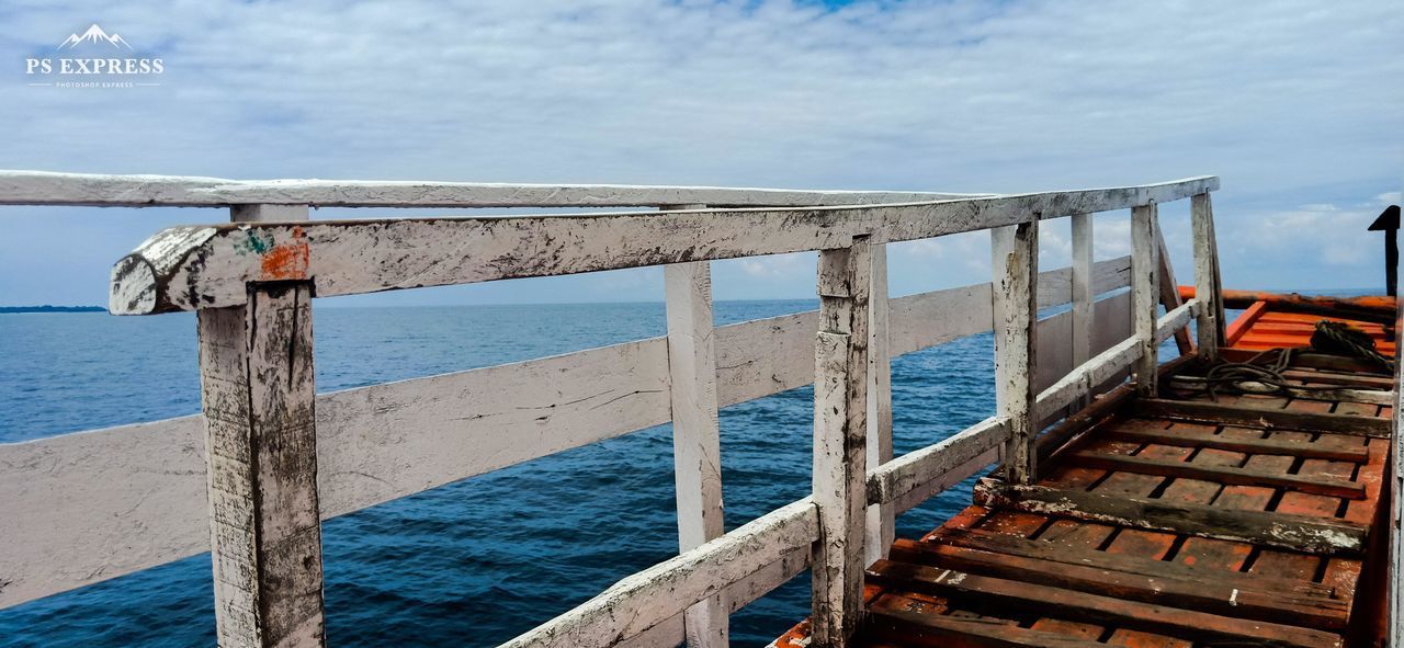 WOODEN POST BY SEA AGAINST BLUE SKY