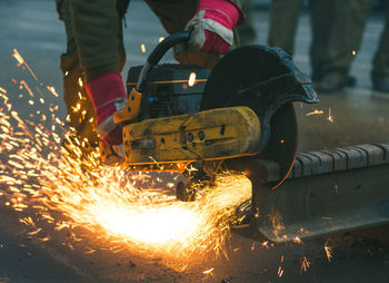 Midsection of man working on metal