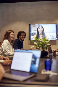 Smiling business colleagues during virtual meeting at creative office