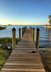 Wooden pier over sea against clear sky