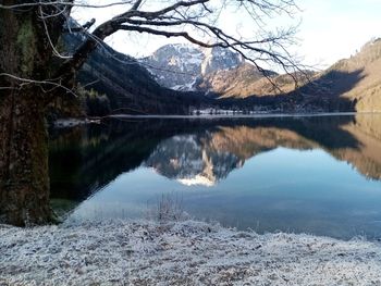 Scenic view of lake by snowcapped mountain against sky