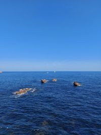 Scenic view of sea against clear blue sky