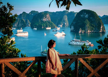 Rear view of woman looking at lake against mountain