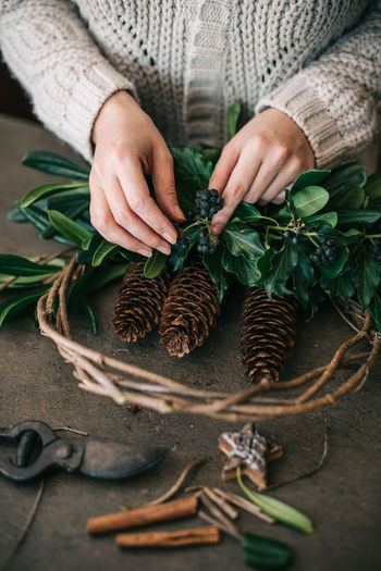 Midsection of woman holding leaves on table