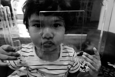 Close-up portrait of cute boy holding camera