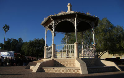 Gazebo in front of building against clear sky