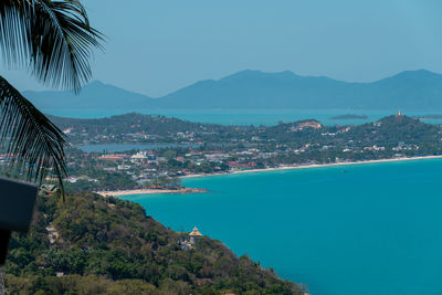 Scenic view of sea and mountains against blue sky