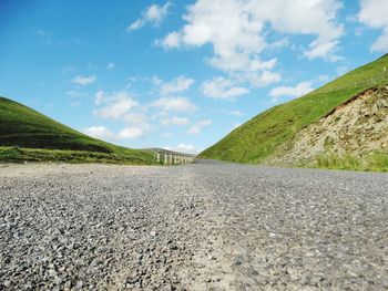 Road by mountain against sky