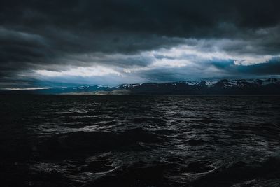 Scenic view of sea against storm clouds