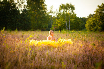 Rear view of woman sitting on grassy field