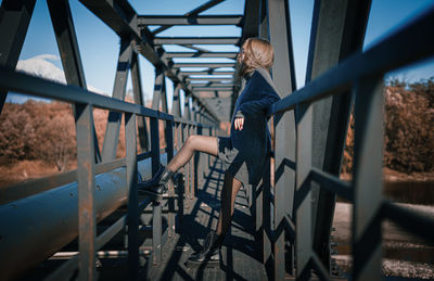 Side view of woman on metal bridge