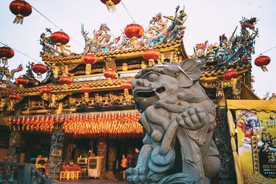 Low angle view of monster statue outside traditional building
