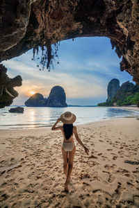 Rear view of woman standing at beach