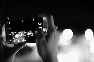 Close-up of man photographing illuminated smart phone