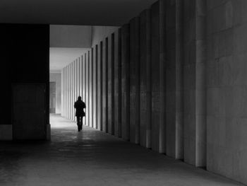 Rear view of silhouette man walking in corridor of building