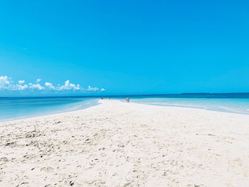 Scenic view of beach against blue sky