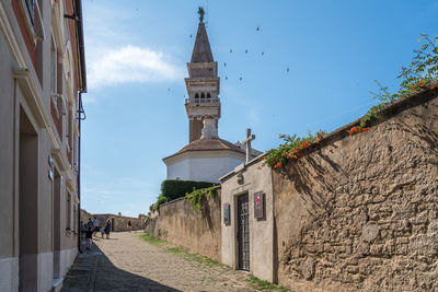 Footpath amidst buildings against sky