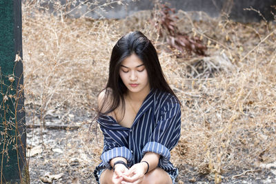 Young woman sitting on field