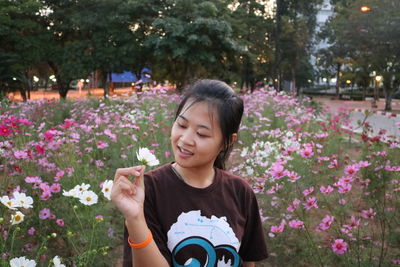 Close-up of baby girl with flowers in park