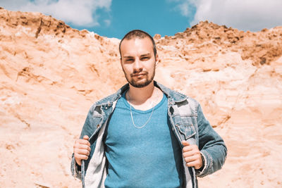 Young man standing against wall