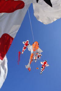 Low angle view of red flags hanging against sky