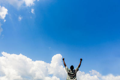 Low angle view of man against blue sky