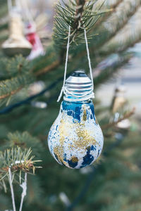 Painted old electric light bulb on christmas tree. diy decoration