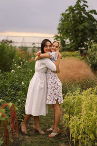 A young mother with a teenage daughter spends time in the garden. family holiday and togetherness.