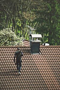 High angle view of chimney sweep walking on roof