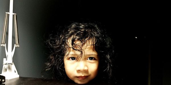 Portrait of cute girl against wall