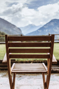 Empty wooden chair against mountain range