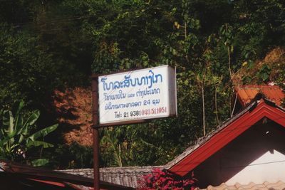 Information sign by trees in forest